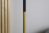 Gold and black cylindrical object against a neutral background